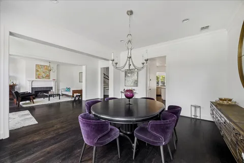 a dining room with furniture a chandelier and wooden floor