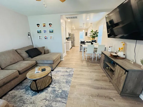 a view of a kitchen with dining table stainless steel appliances and wooden floor