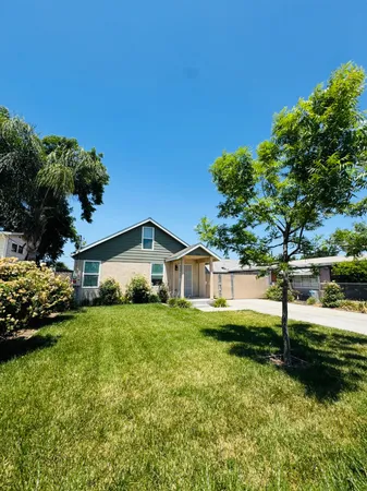a view of a house with a yard and sitting area