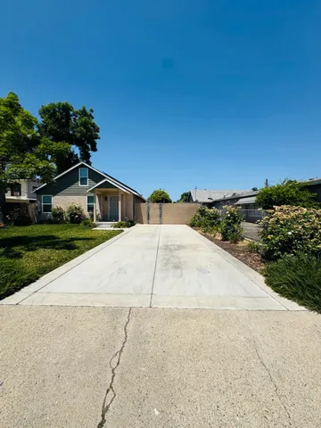 a house with a yard and a trees in front of it