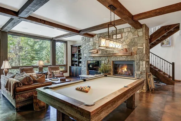 a living room with furniture a fireplace and a large window