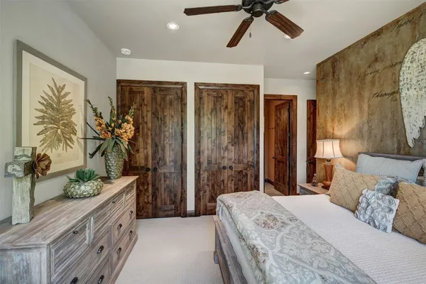 a bedroom with a large bed and a chandelier