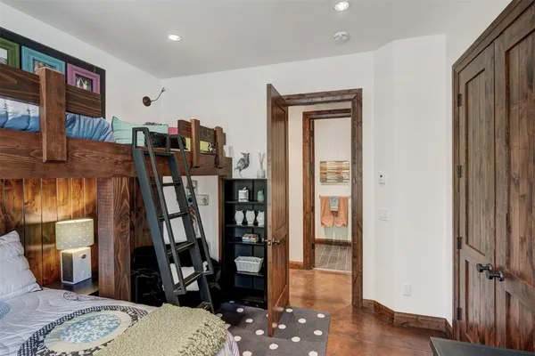 a walk in closet with wooden floor