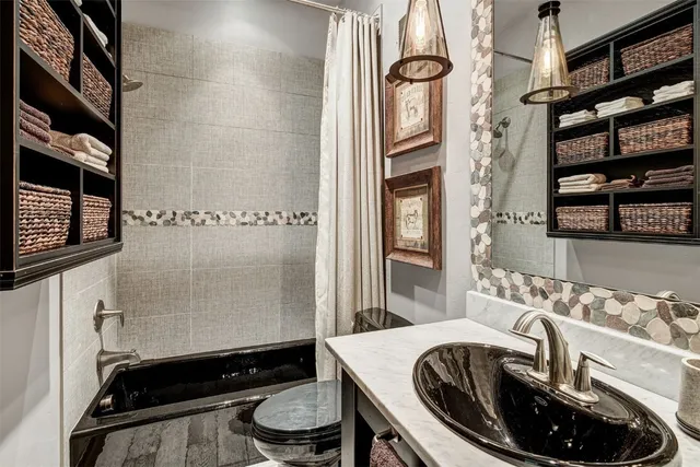 a bathroom with a sink a toilet and shower