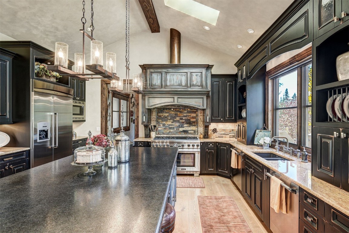 67 Rounds Road Breckenridge, CO 80424 - Photo 10 of 47 a kitchen with stainless steel appliances granite countertop a stove top oven a sink dishwasher a dining table and chairs with wooden floor