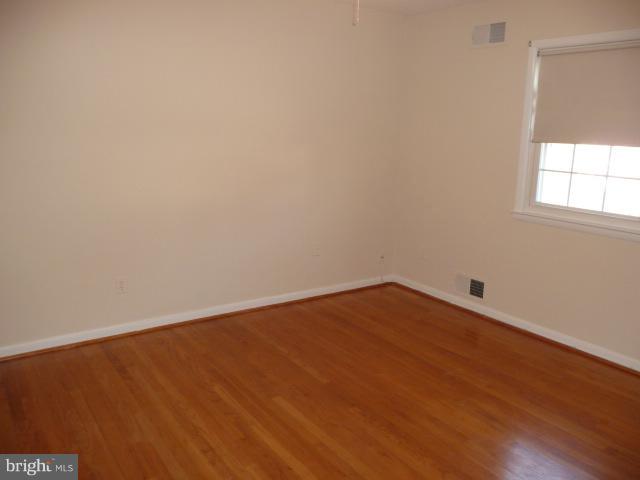 625 Cleveland Road Linthicum Heights, MD 21090 - Photo 16 of 28 a view of an empty room with wooden floor and a window