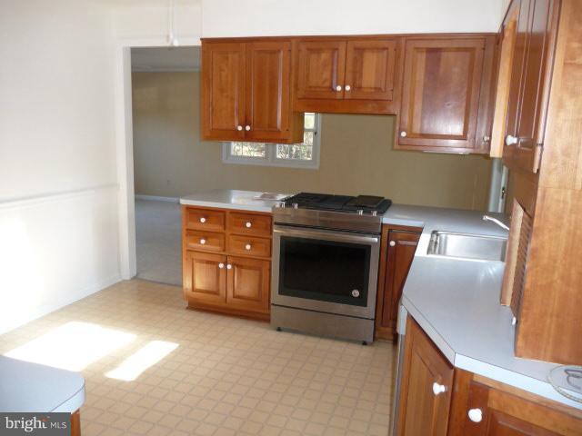 625 Cleveland Road Linthicum Heights, MD 21090 - Photo 6 of 28 a kitchen with wooden cabinets and a stove top oven
