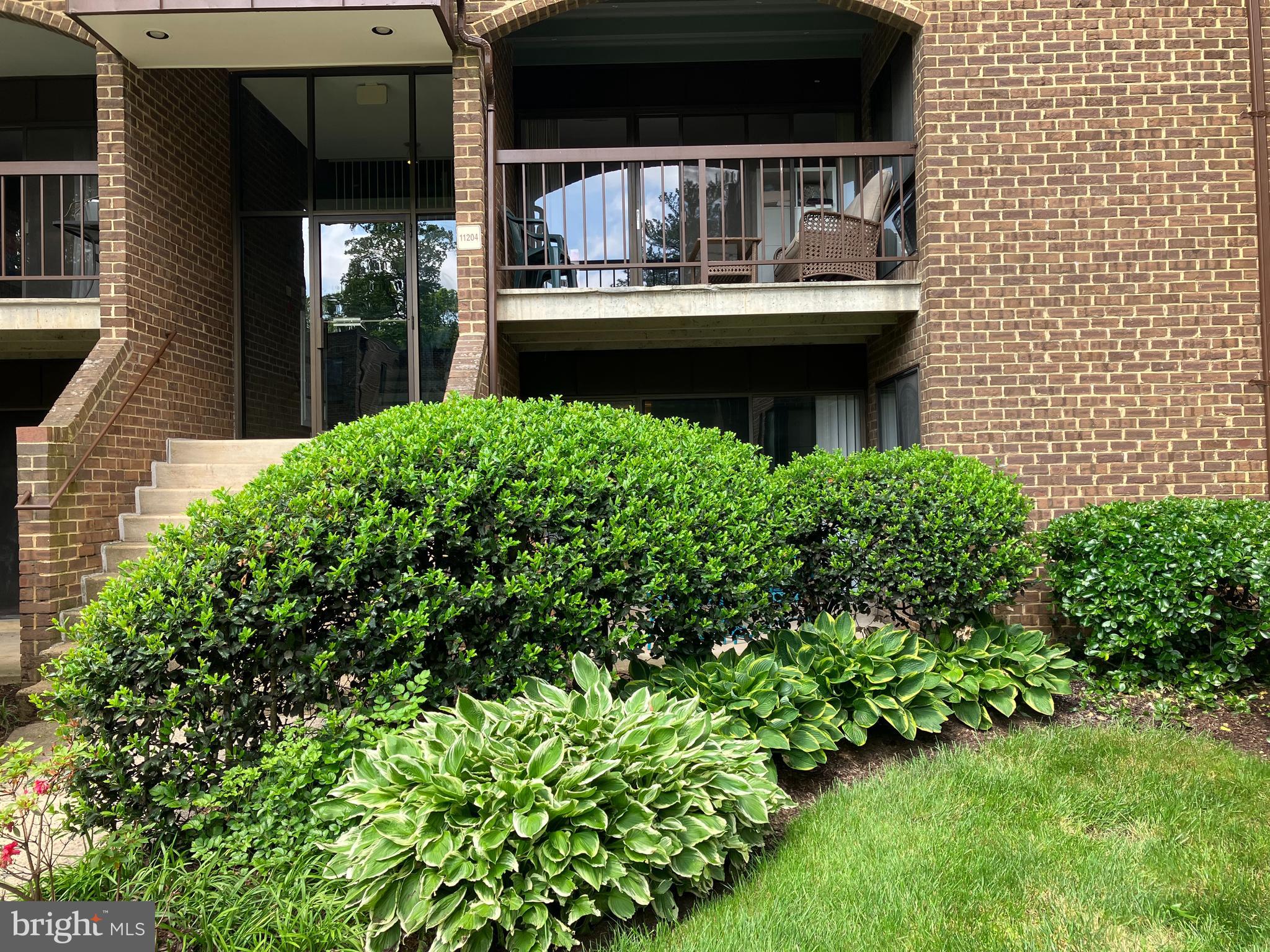 11204 Chestnut Grove Square, Unit 11204108 Reston, VA 20190 - Photo 24 of 40 a front view of a house with garden