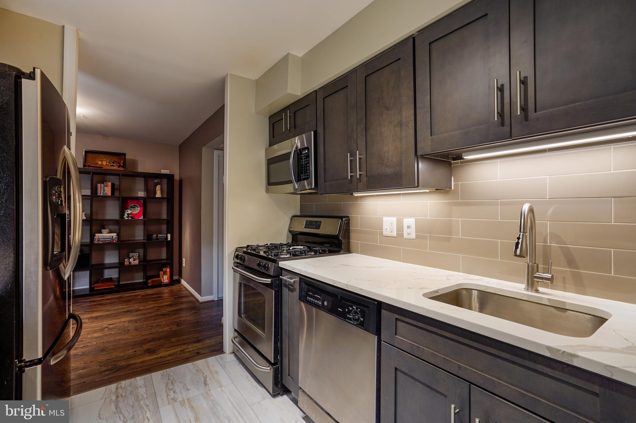 11204 Chestnut Grove Square, Unit 11204108 Reston, VA 20190 - Photo 3 of 40 a kitchen with stainless steel appliances granite countertop a sink stove and cabinets