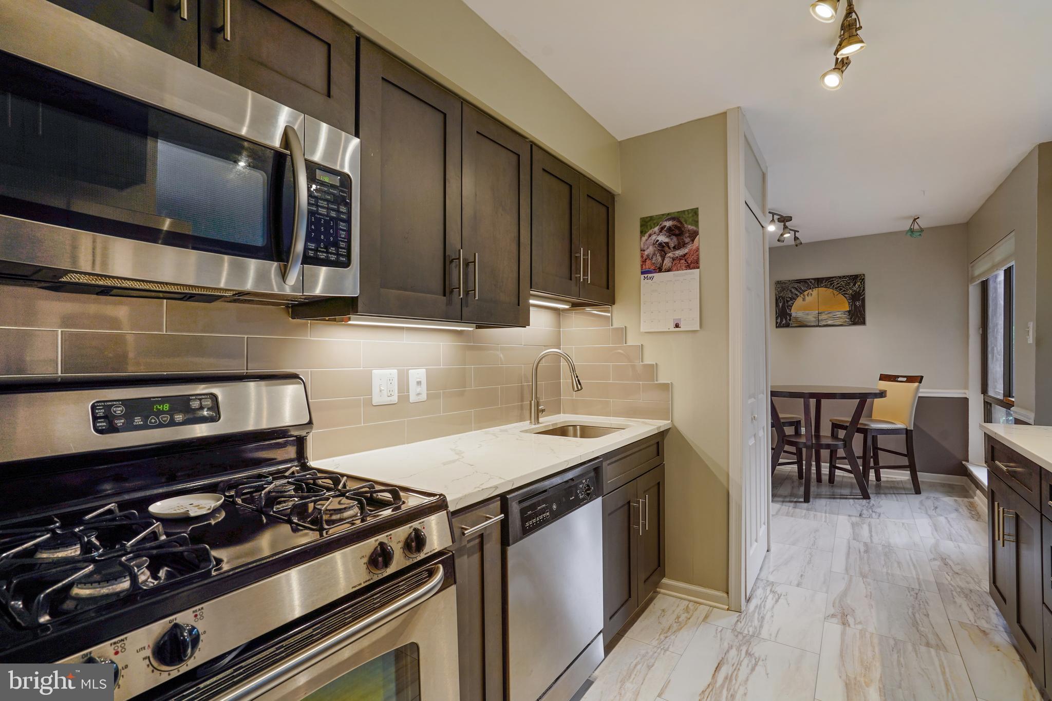 11204 Chestnut Grove Square, Unit 11204108 Reston, VA 20190 - Photo 5 of 40 a kitchen with a stove and a microwave
