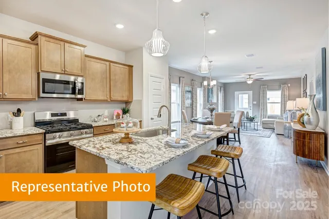 a kitchen with stainless steel appliances kitchen island granite countertop a stove a sink a dining table and chairs with wooden floor