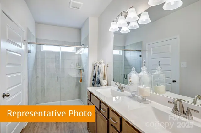 a bathroom with a sink vanity granite and a shower