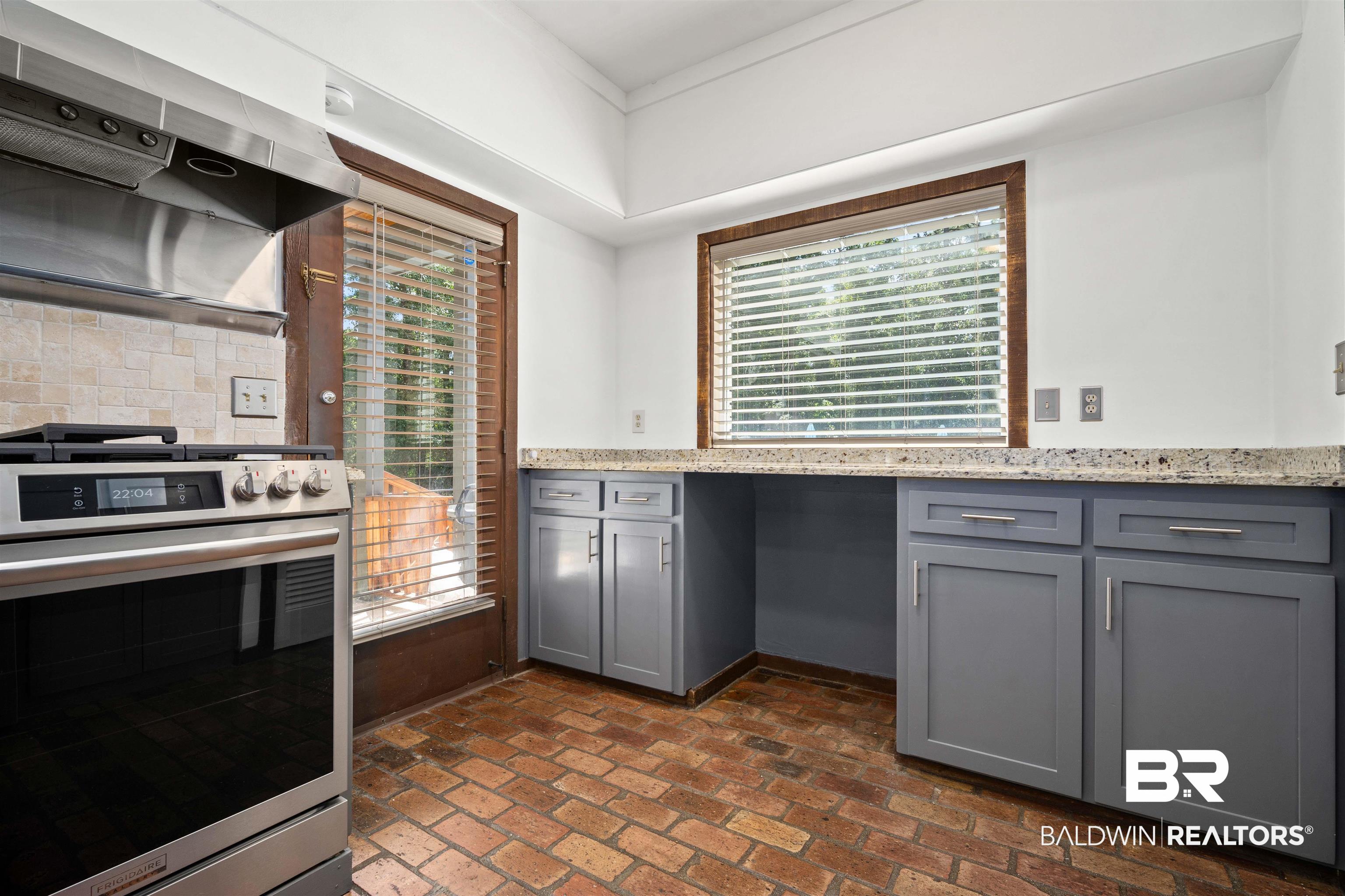 7912 Yorkhaven Road Mobile, AL 36695 - Photo 9 of 41 Kitchen featuring gray cabinets, stainless steel stove, brick floors, and light stone countertops