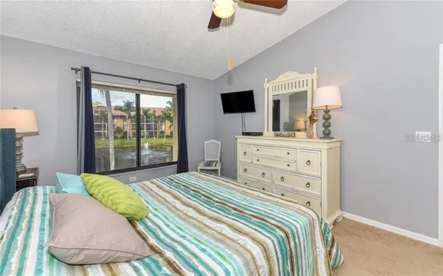 a bedroom with a large bed and a flat tv screen on dresser