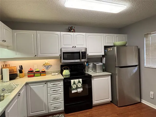 a kitchen with refrigerator a stove a sink and cabinets