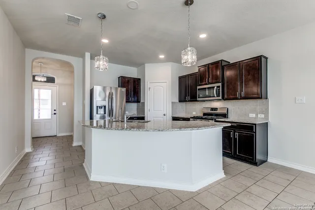 a kitchen with stainless steel appliances granite countertop a sink refrigerator and microwave