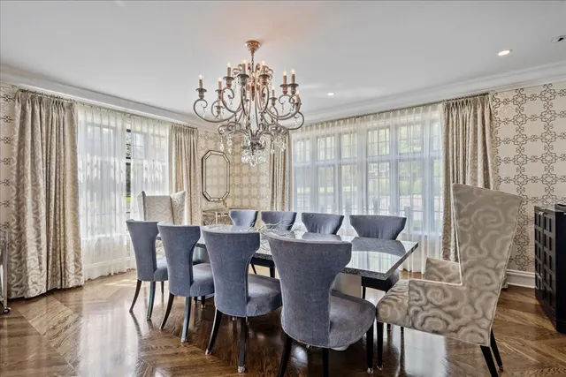 a kitchen with stainless steel appliances granite countertop a stove top oven a sink a dining table and chairs with wooden floor