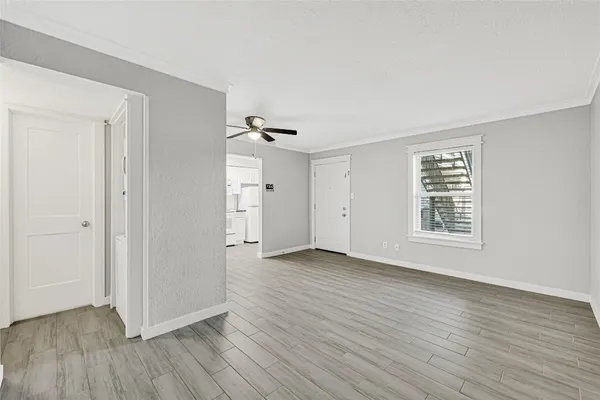 a view of an empty room with wooden floor