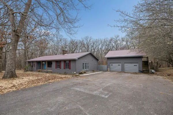 a front view of a house with yard and trees