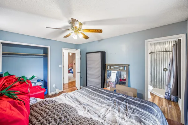 an empty room with a chandelier fan and windows