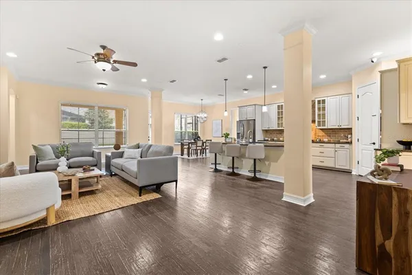 a living room with furniture kitchen view and a chandelier