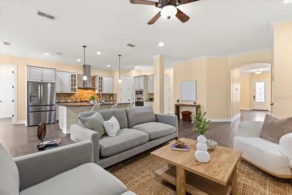 a kitchen with stainless steel appliances granite countertop a stove top oven a refrigerator a sink and chairs