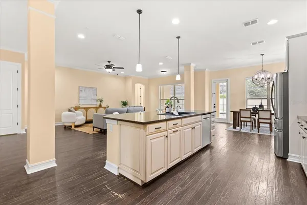 a kitchen with a dining table chairs and a refrigerator