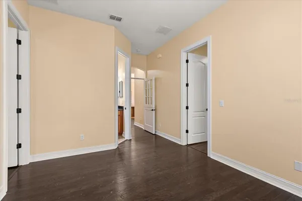 a view of an empty room with wooden floor