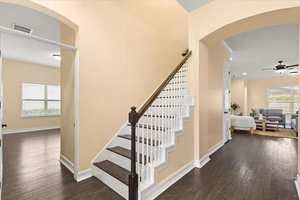a living room with furniture kitchen area and a chandelier