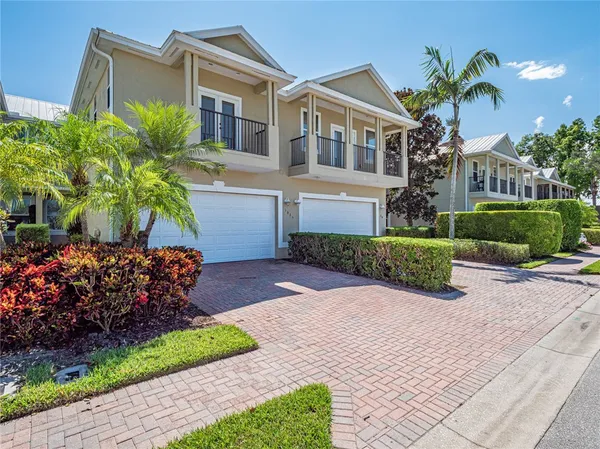 a front view of a house with a yard and potted plants