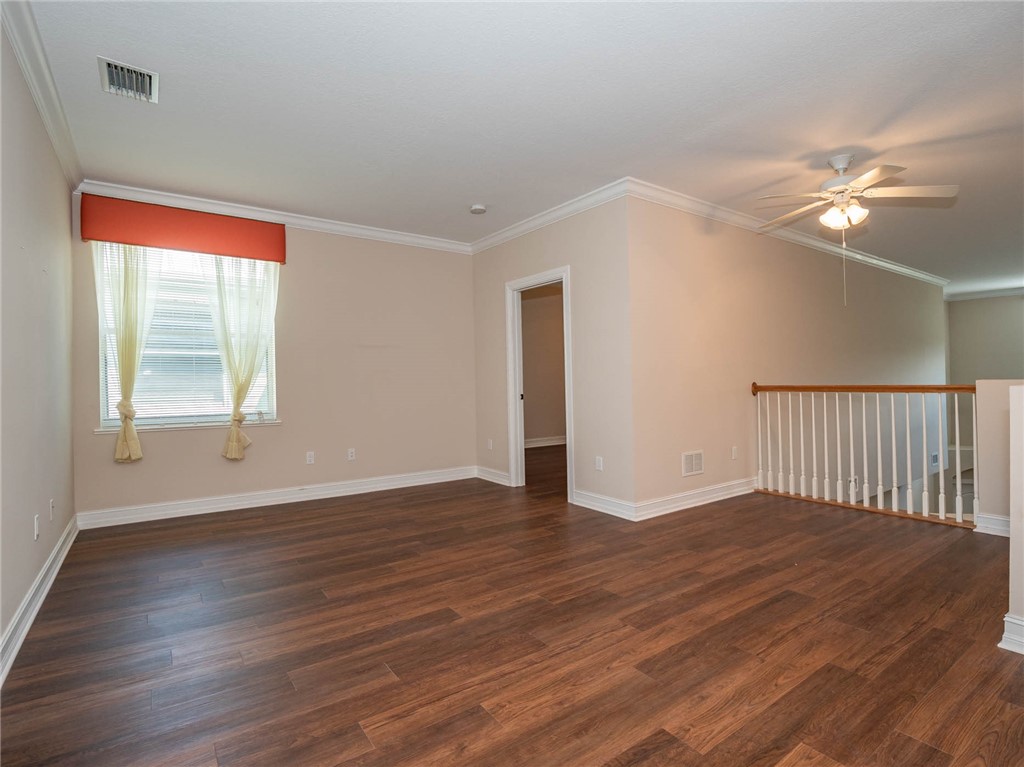1875 Bridgepointe Circle, Unit 33 Vero Beach, FL 32967 - Photo 11 of 33 a view of an empty room with wooden floor and a window