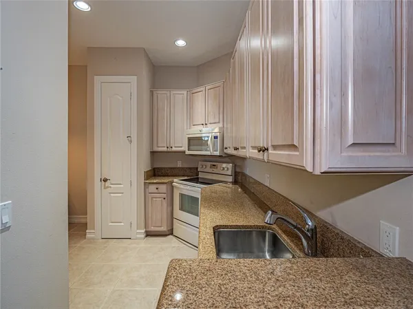 a kitchen that has a sink cabinets and stainless steel appliances