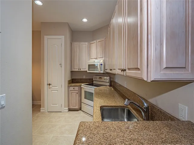 a kitchen that has a sink cabinets and stainless steel appliances