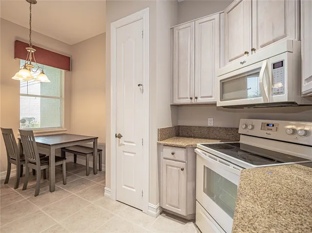 a kitchen with a stove and white cabinets