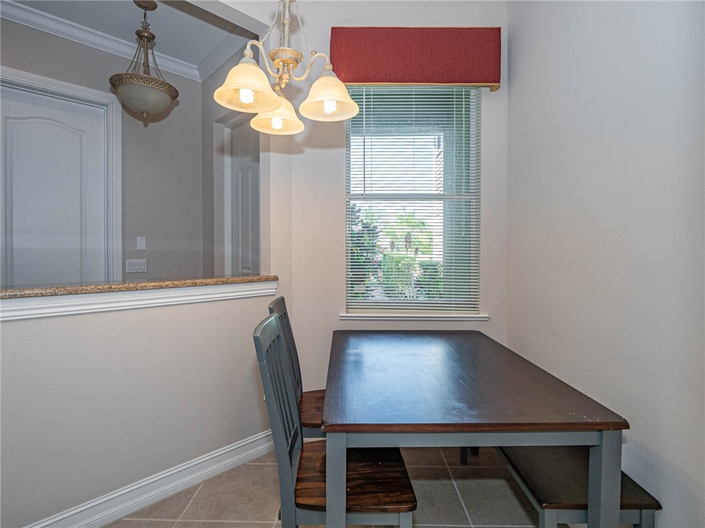 1875 Bridgepointe Circle, Unit 33 Vero Beach, FL 32967 - Photo 14 of 33 a view of a dining room with furniture and a chandelier