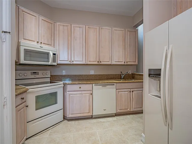 a kitchen with granite countertop white cabinets and stainless steel appliances
