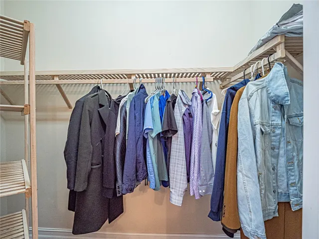 a view of walk in closet with clothes