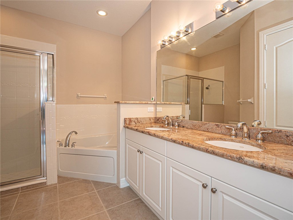 1875 Bridgepointe Circle, Unit 33 Vero Beach, FL 32967 - Photo 21 of 33 a bathroom with a granite countertop sink a toilet and a mirror