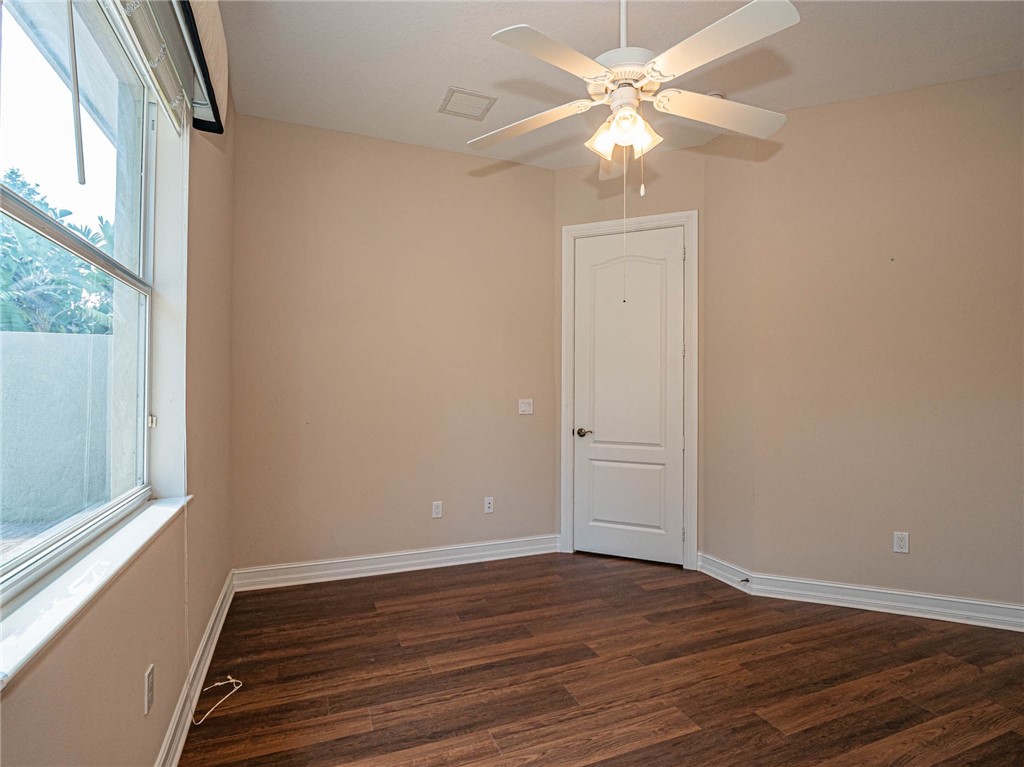 1875 Bridgepointe Circle, Unit 33 Vero Beach, FL 32967 - Photo 25 of 33 a view of an empty room with wooden floor and a window