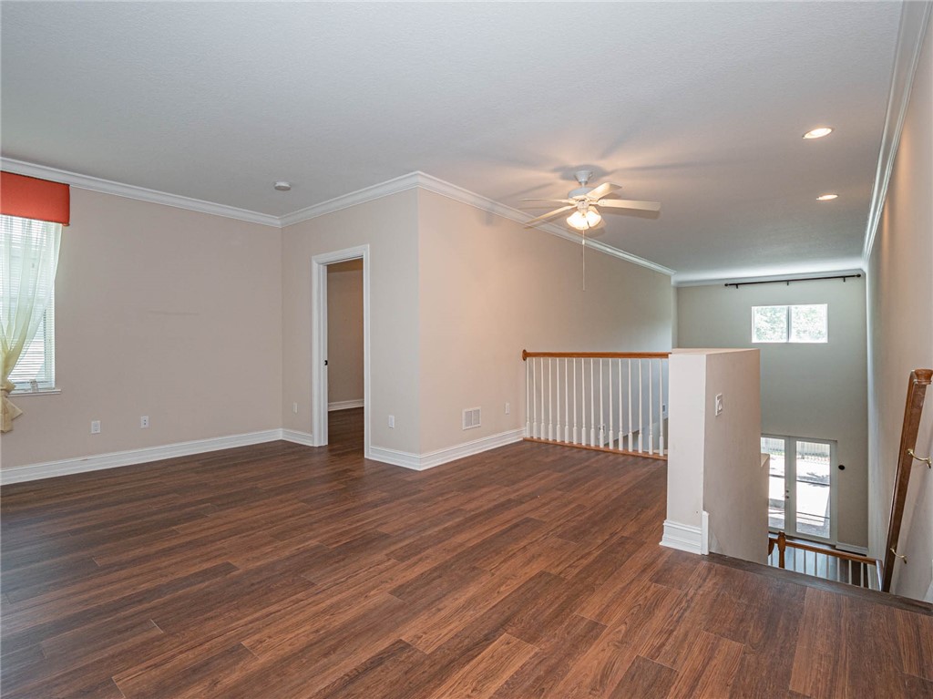 1875 Bridgepointe Circle, Unit 33 Vero Beach, FL 32967 - Photo 10 of 33 a view of an empty room with wooden floor and a ceiling fan