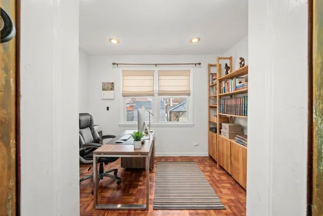 a view of a workspace with furniture and a window
