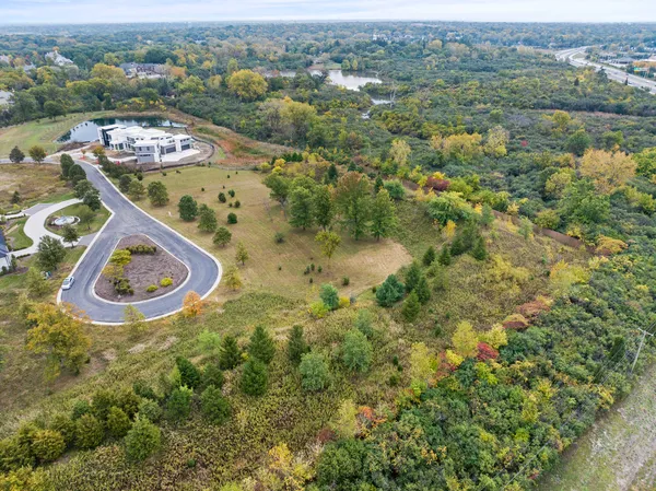 an aerial view of residential house with outdoor space and trees all around