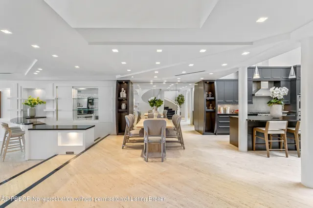 a large white kitchen with lots of counter space and furniture