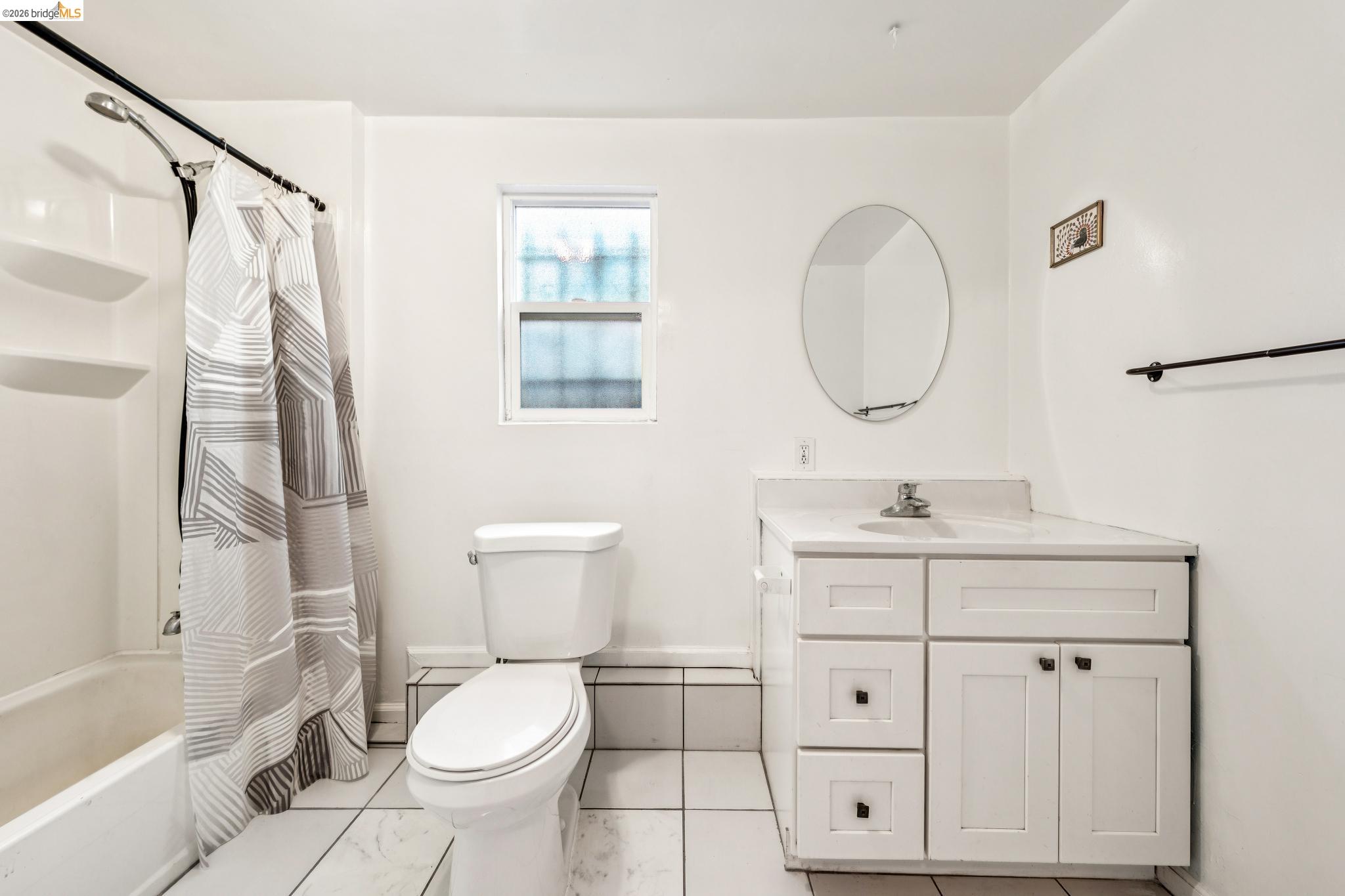 836 20th Street Oakland, CA 94607 - Photo 34 of 54 a bathroom with a toilet a sink a mirror a bathtub and shower