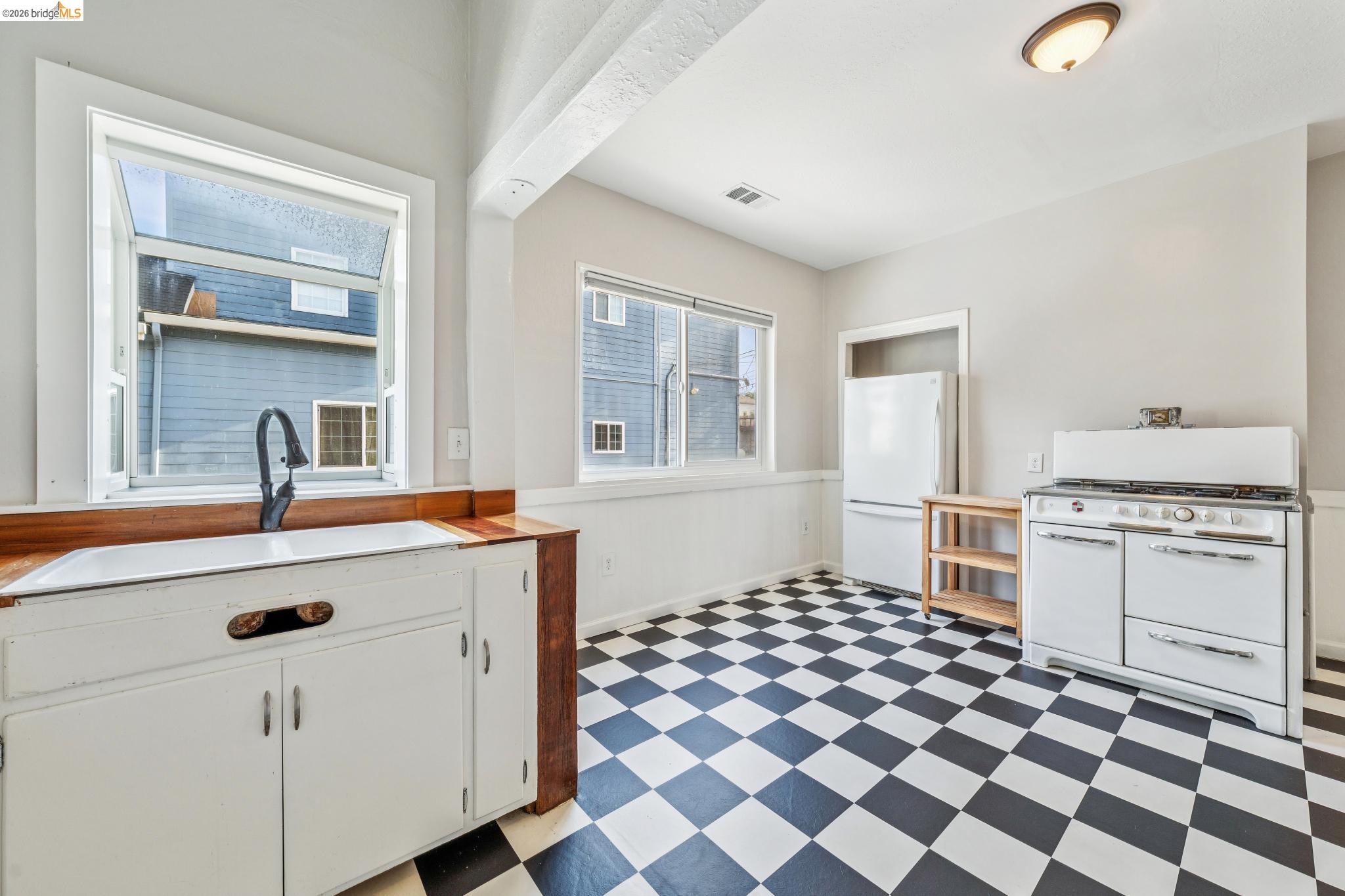 836 20th Street Oakland, CA 94607 - Photo 8 of 54 a kitchen with a sink a stove and a refrigerator