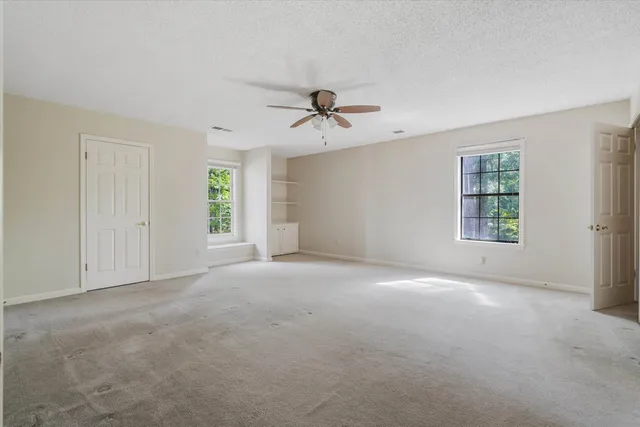 a view of a room with windows and chandelier fan