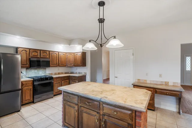 a kitchen with a sink a stove and chairs