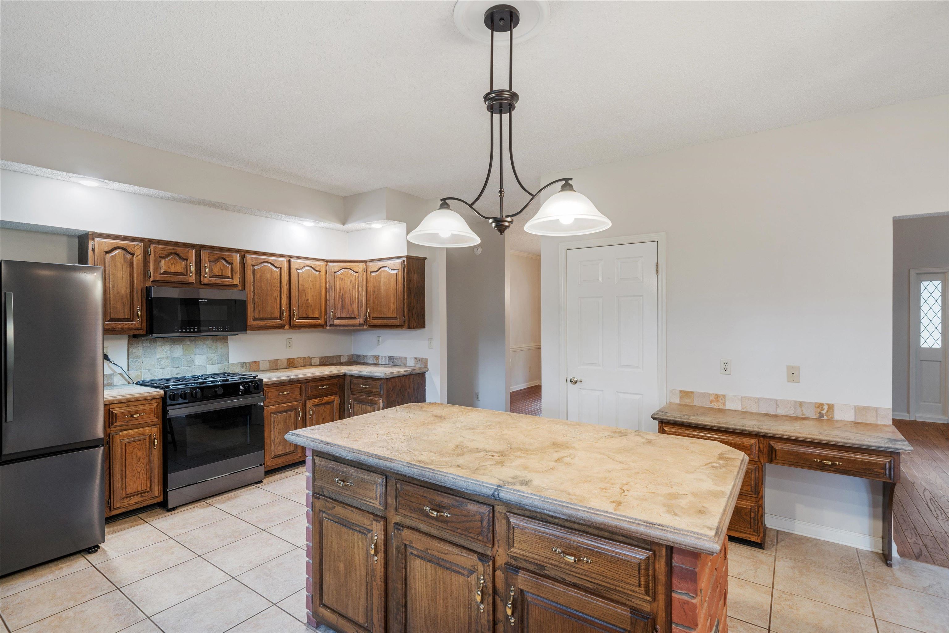 4309 Garner Place Bartlett, TN 38135 - Photo 6 of 40 a kitchen with a sink a stove and chairs