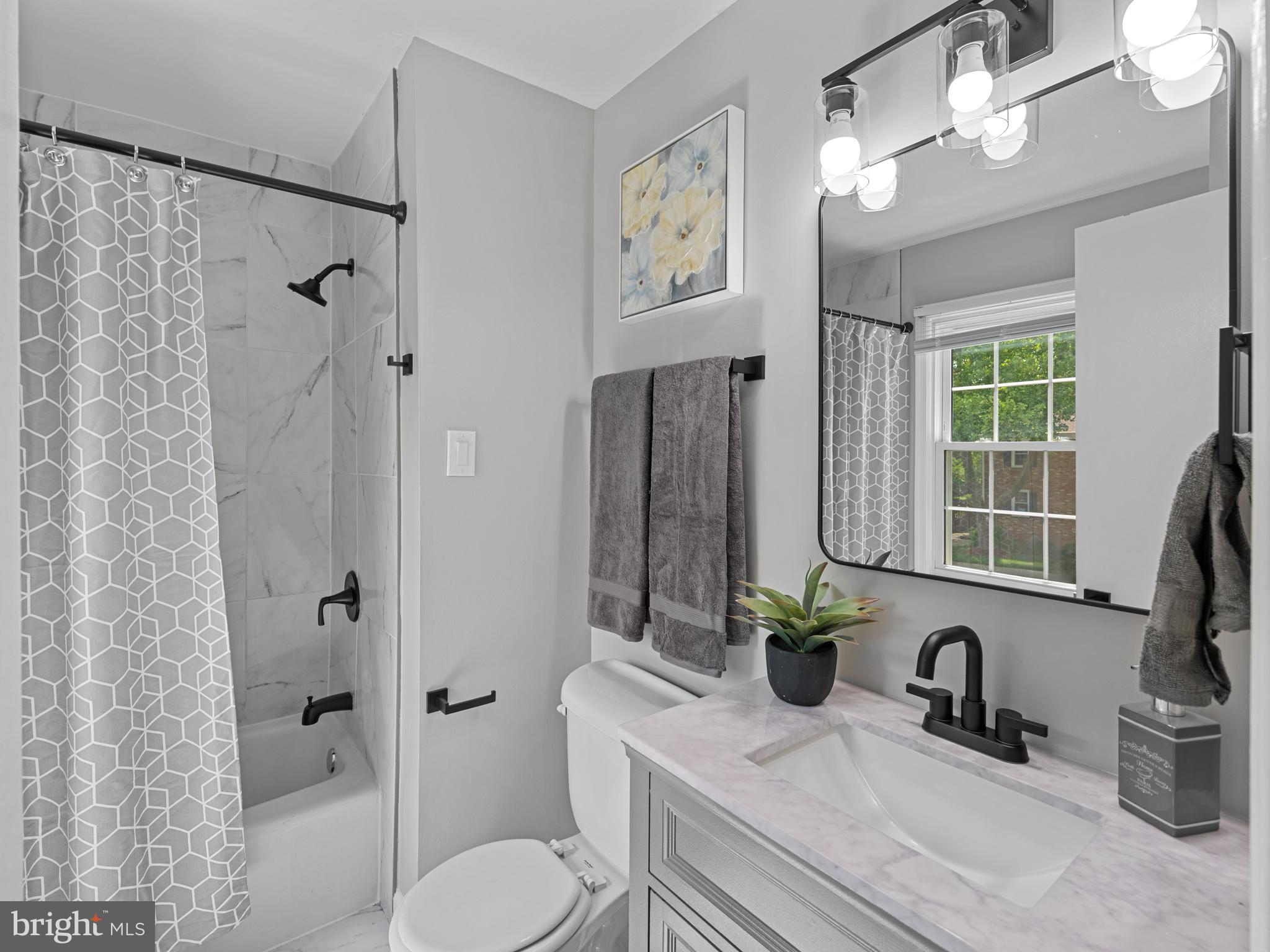 8448 Kitchener Drive Springfield, VA 22153 - Photo 16 of 32 a bathroom with a granite countertop sink a toilet and shower