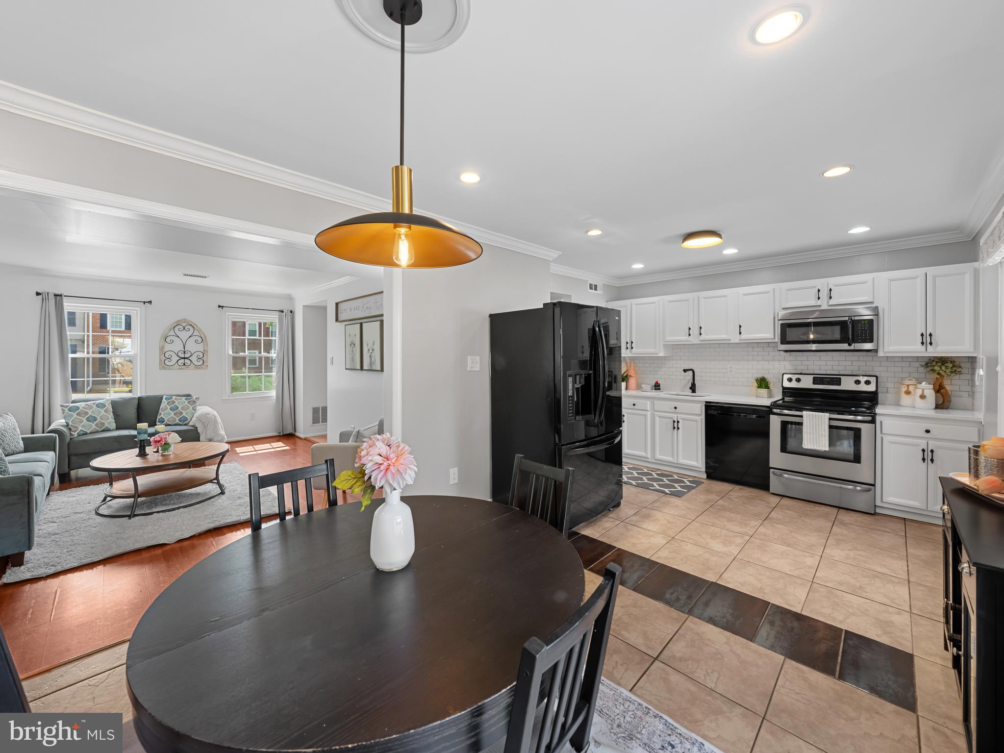 8448 Kitchener Drive Springfield, VA 22153 - Photo 18 of 32 a kitchen with stainless steel appliances granite countertop a dining table chairs stove refrigerator and microwave